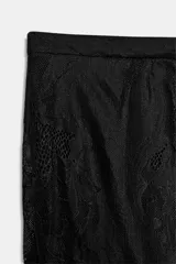 Pantalón bombacho de encaje negro con tiro medio, cintura elástica, forro corto interior y puños elásticos en el tobillo.