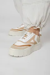 Zapatillas deportivas de cuero color beige, blanco y marrón, con cordones y suela de goma.