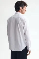 Camisa blanca de manga larga con tratamiento de fácil planchado, cuello inglés y corte regular fit.