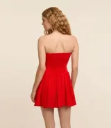 Vestido corto con pollera balonê, escote sin breteles, cierre por cremallera en el lateral y confeccionada en viscolino.