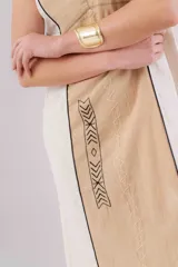 Vestido largo de lino con diseño bicolor en beige y crudo, escote en V y breteles regulables. Presenta detalles de bordados geométricos en el frente y tajos laterales.