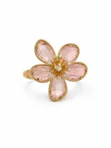 Anillo con diseño de flor, compuesto por pétalos de cristal rosado translúcido con borde dorado y centro decorado con pequeñas circonias brillantes sobre base de acero.