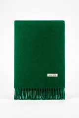 Bufanda verde de lana con flecos en los extremos y etiqueta decorativa con la inscripción "wool 100%".