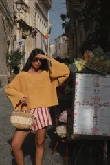 Buzo de tejido de punto acanalado color amarillo mostaza, con escote en V y mangas amplias.