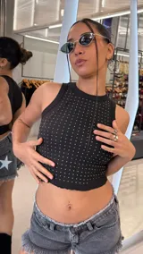 Top negro de morley al cuerpo, sin mangas, con escote redondo y aplicaciones de strass plateados distribuidos por toda la prenda.