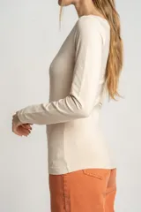 Remera color crema de algodón y elastano, de corte ajustado y mangas largas, con cuello barco.