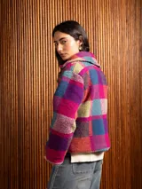 Chaquetón corto de lana con diseño de cuadros en tonos tierra y borravino, con solapas amplias y cierre frontal de botones.