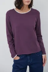 Remera de manga larga en color azul marino, confeccionada en tejido suave. Presenta un delicado detalle de bordado festoneado en color blanco tanto en el cuello redondo como en los puños, aportando un toque distintivo a esta prenda básica.