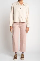 Camisa tipo sobrecamisa oversize color crudo, confeccionada en tejido de gamuza vegana con cierre frontal de botones metálicos y cuello clásico.