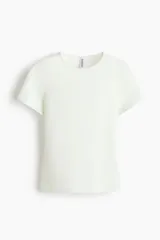 Remera de manga corta color blanco, de corte entallado con cuello redondo y bajo recto.