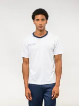 Remera de manga corta Umbro, color blanco, con cuello redondo en contraste azul marino y logo de la marca bordado en el pecho.