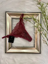 Tanga de encaje color bordó, corte media colaless y regulable.