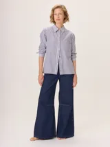 Camisa de manga larga con diseño combinado. Presenta mangas y parte superior delantera y trasera en color negro liso, mientras que el panel central de la espalda destaca por un estampado animal print de leopardo. Cuenta con cuello clásico, cierre frontal de botones y puños abotonados.