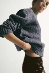 Jersey de punto jaspeado con cuello redondo y detalle de costura en V frontal, manga larga y terminaciones en rib.