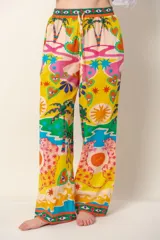 Pantalón de corte holgado y tiro medio con cintura elástica y cordón ajustable. Presenta un estampado colorido y vibrante con motivos tropicales, corazones, soles y figuras de felinos.