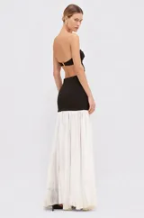 Vestido largo strapless bicolor con diseño cut-out en la cintura, apliques florales tridimensionales en el lateral y falda larga plisada blanca.