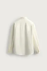 Camisa regular fit de color celeste, confeccionada en tejido con mezcla de algodón y seda, con cuello solapa, manga larga con puño abotonado y cierre frontal de botonadura.