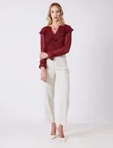 Pantalón sastrero color beige, de corte recto y tiro alto, con largo al tobillo. Tiene pretina limpia con cierre interno y pasadores, y bolsillos funcionales en la parte delantera.