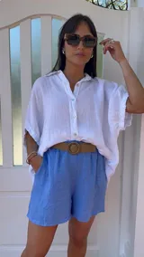 Short de lino color rojo, con cintura elástica y cinturón de rafia con hebilla circular.