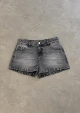 Short de jean negro de tiro bajo, con efecto acid wash y diseño corto ajustado.