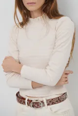 Polera de manga larga con cuello alto y detalle de volados en el borde. Confeccionada en tejido acanalado de textura suave y ajuste al cuerpo.