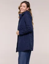 Campera larga de color azul marino con diseño capitoneado geométrico, capucha desmontable y cierre frontal completo. Cuenta con bolsillos laterales con cierre y ajuste en la cintura.