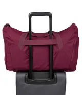 Bolso deportivo tipo duffel de la marca Jansport, color bordó, con compartimento principal con cierre, asas de mano y correa ajustable para el hombro.