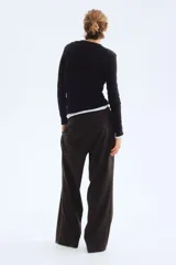 Pantalón amplio color negro, de corte holgado con pinzas, cierre con botón y corchetes ocultos, bolsillos laterales y piernas con pliegues adelante y atrás.