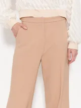 Pantalón de vestir color beige, de corte palazzo y tiro alto.