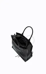 Cartera tipo tote de gran tamaño, color negro, con diseño estructurado y superficie perforada tipo mesh. Cuenta con doble asa de mano y cierre interno con cordón ajustable.