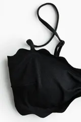Top de bikini con relleno, ribetes festoneados y costura fruncida en el centro del busto. Cuenta con breteles ajustables y varillas laterales.
