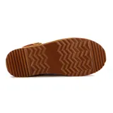 Zuecos de gamuza color tostado con plataforma dentada, forro interior sintético tipo corderito y tira superior decorativa con bordado étnico en tonos rojos y beige.