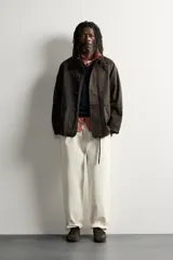 Chaqueta relaxed fit marrón oscuro confeccionada en tejido de algodón. Presenta cuello solapa, manga larga ranglán, bolsillos frontales de plastrón, efecto lavado y cierre frontal con botonadura. Colección especial Aaron Levine x Zara.