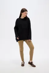 Sweater de punto negro, con cuello redondo a la base, manga larga y diseño holgado.