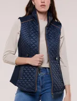 Chaleco acolchado de diseño entallado color beige, con matelaseado en patrón de rombos en frente y espalda, cuello alto estructurado y cierre frontal completo con cremallera metálica y ribete a contraste.