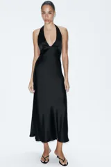 Vestido midi de satén color negro con cuello halter, escote en pico y espalda descubierta con cierre de lazada.