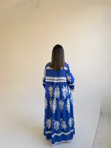 Vestido largo color azul con estampado ornamental en color blanco, escote en V con botones frontales y mangas tres cuartos con volados.