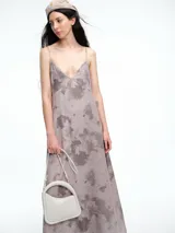 Vestido largo de breteles finos con escote en V, confeccionado en lyocell con estampa orgánica efecto lavado. Presenta una silueta levemente evasé con caída recta y fluida.