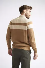 Campera tejida de algodón con diseño color block en tonos beige y marrón. Presenta cierre frontal completo, cuello alto y textura acanalada.