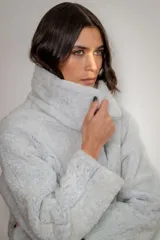Campera reversible de cuero ovino con interior de piel sintética, diseño oversize, cierre frontal con broches y bolsillos laterales.