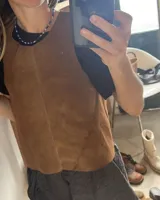 Chaleco negro de cuero agamuzado con espalda cruzada.