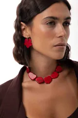 Collar corto tipo gargantilla compuesto por piedras rojas de forma irregular con acabado texturizado, montadas sobre una base de mostacillas y cierre de cadena de acero quirúrgico ajustable.