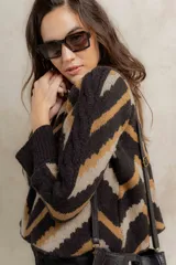 Sweater de punto jacquard con diseño de chevron en tonos celeste y marrón. Presenta cuello redondo, corte holgado y mangas largas con hombros abullonados.