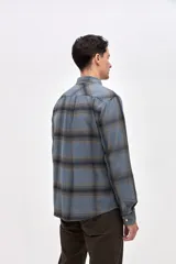 Sobrecamisa de algodón con diseño a cuadros en tonos azules, cuello clásico, cierre frontal con botones y dos bolsillos en el pecho con solapa.