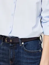 Camisa celeste de popelín de algodón orgánico, corte regular, cuello inglés, puños con botón, bajo redondeado y logo de Tommy Hilfiger bordado en el pecho.