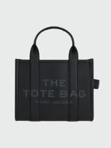 Cartera tipo tote de Marc Jacobs, confeccionada en cuero granulado negro. Presenta el logo de la marca estampado en el frente y doble asa superior.