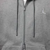 Campera gris con capucha y cierre completo, con logo de Jordan bordado en el pecho.
