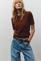 Jersey de punto fino con cuello redondo y manga corta, con terminaciones en rib en cuello, mangas y ruedo.