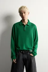Polo de punto de manga larga en color verde, confeccionado en hilatura de lana. Presenta cuello solapa, cierre frontal con botonadura y acabados en rib en puños y bajo.