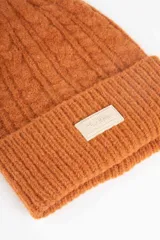 Gorro de lana tejido en ochos con vuelta acanalada y parche frontal con logo de la marca Daniel Cassin.